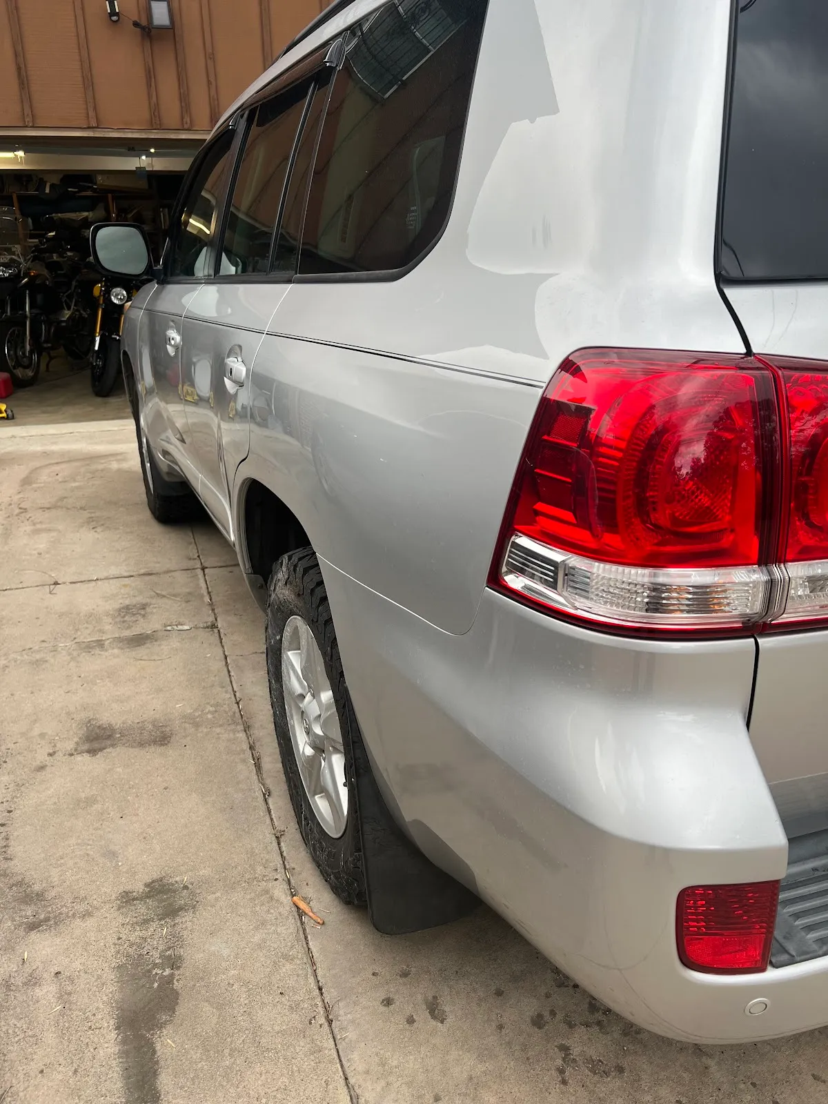 A silver Toyota Land Cruiser parked beside the service bays