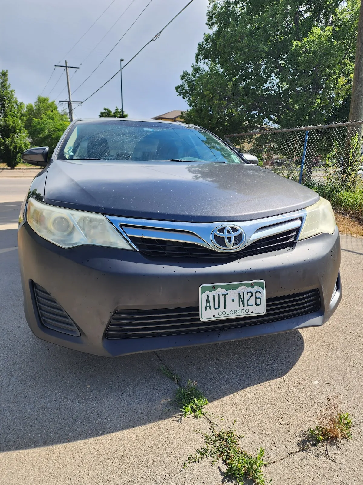 A gray Toyota Camry out front, ready for pickup after service