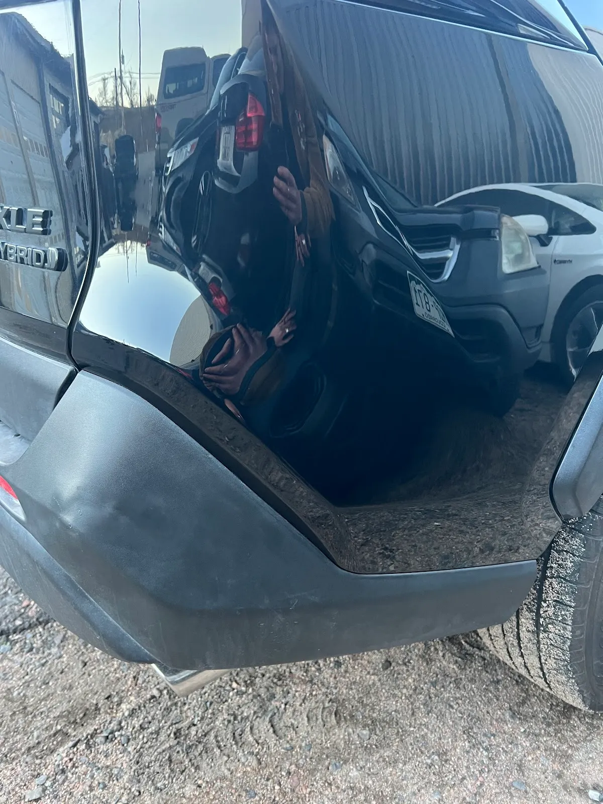 Rear-end collision damage on a black car, before repair